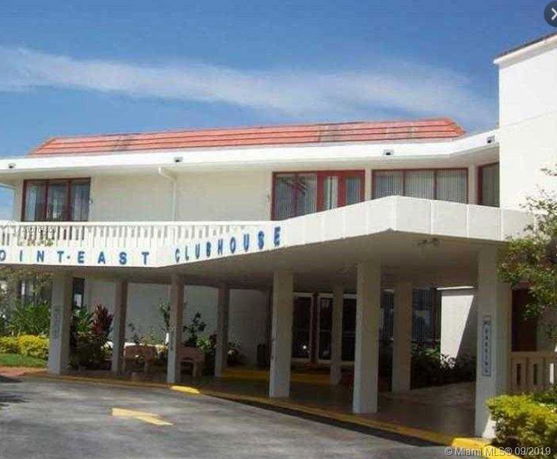Front view of a clubhouse with a flat roof and large windows.