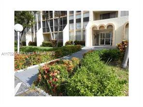 Front view of a multi-story building with a landscaped entrance.