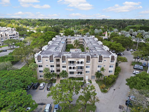 Aerial view of a multi-story apartment building with parking lot.