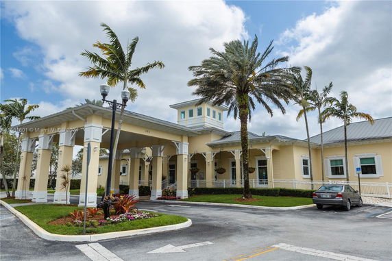Front view of a single-story building with a covered entrance and large windows.