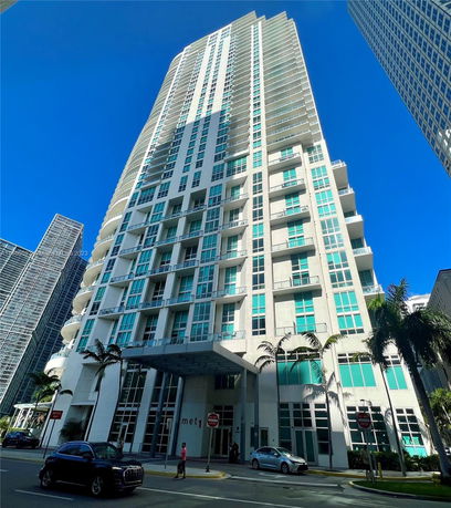Front view of a high-rise building with multiple balconies and large glass windows.