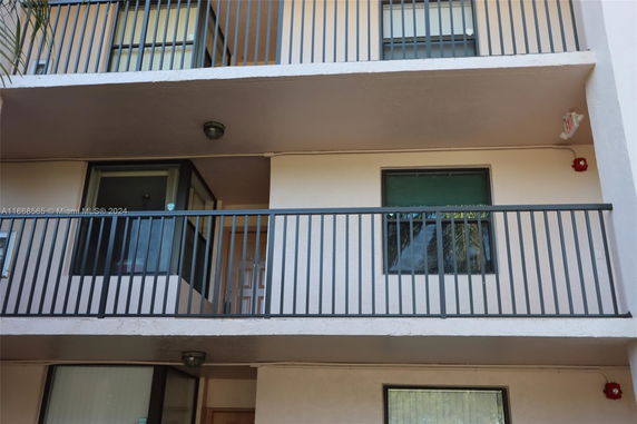 Front view of a building with balconies and metal railings.