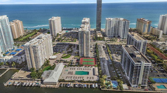 Panoramic view of high-rise buildings near the ocean with outdoor spaces and swimming pool.