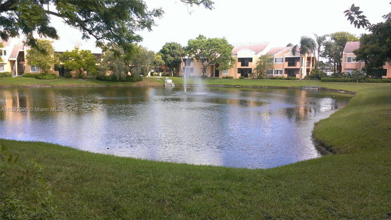 View of buildings by a pond with a fountain.