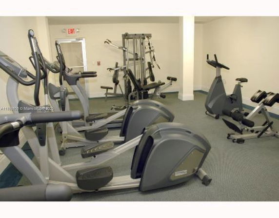 Indoor gym area with exercise machines and equipment.