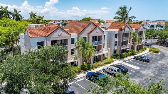Front view of a multi-story building with balconies and a red-tiled roof.