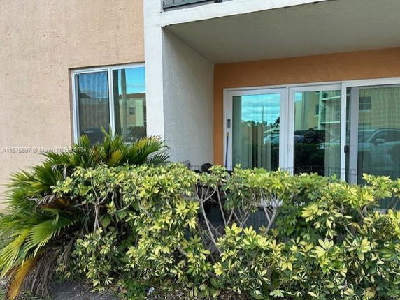 Front view of a building with a patio and sliding glass doors.