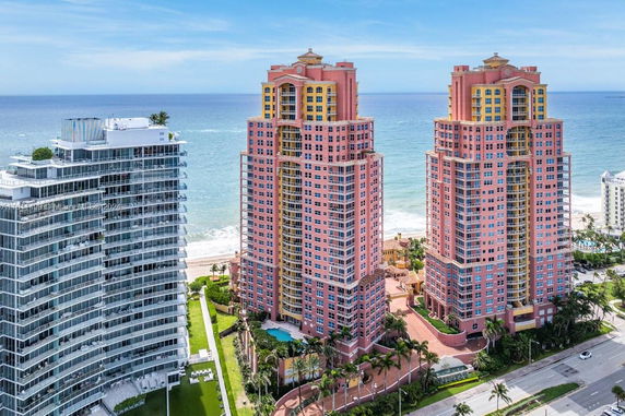 Front view of two high-rise buildings with ocean in the background.