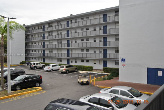 Front view of a multi-story apartment building with balconies.