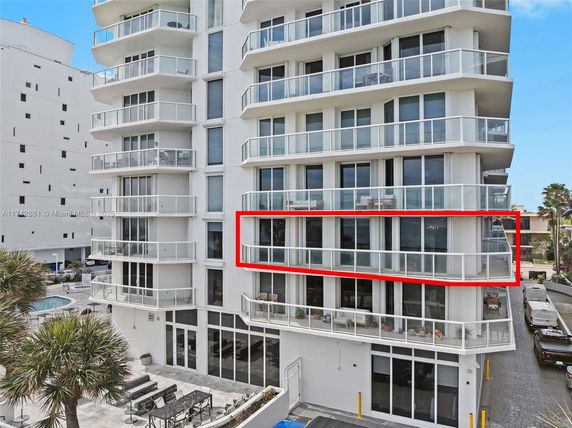 Front view of a multi-story modern apartment building with balconies.
