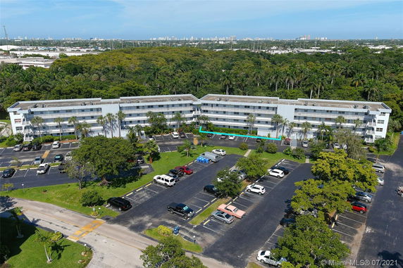 Front view of a multi-story building with adjacent parking area.