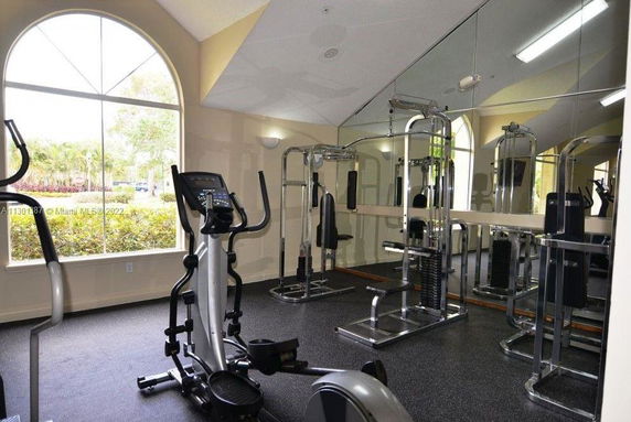 Indoor area with gym equipment and mirrored walls.