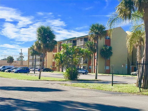 Front view of a multi-story residential building with balconies.