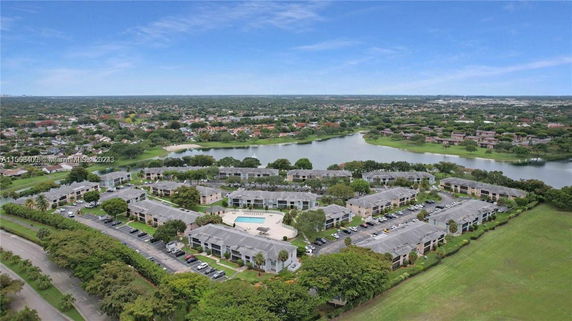 Panoramic aerial view of residential complex with communal pool and surrounding landscape.