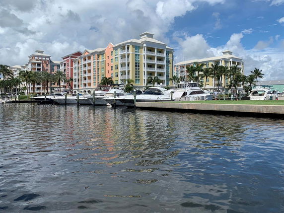 View of multi-story buildings by a waterfront with boats docked nearby.