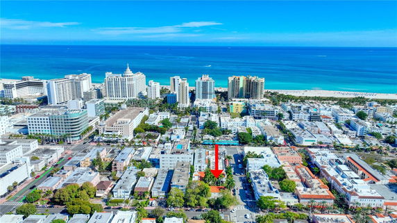 Aerial view of a coastal city with various buildings and the ocean in the background.