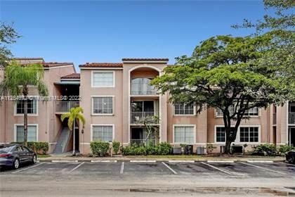 Front view of a multi-story apartment building with balconies and parking area.