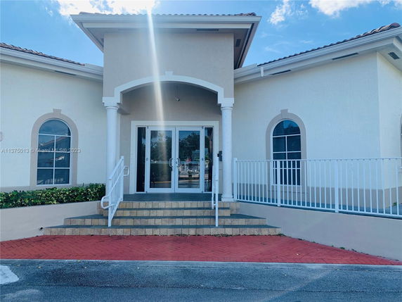 Front view of a building with an entrance featuring steps and an archway.