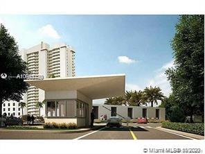 Front view of a modern, low-rise building with a large overhanging roof, set against taller residential towers.