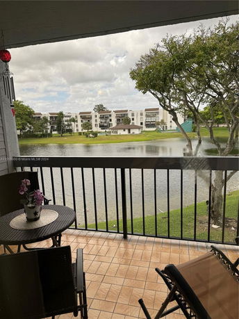 Balcony view overlooking a body of water and residential buildings in the background.