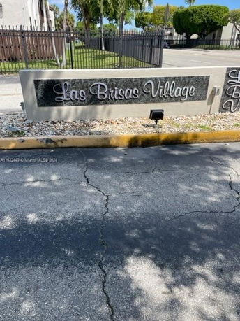 Entrance sign of Las Brisas Village with a stone background and decorative lettering.