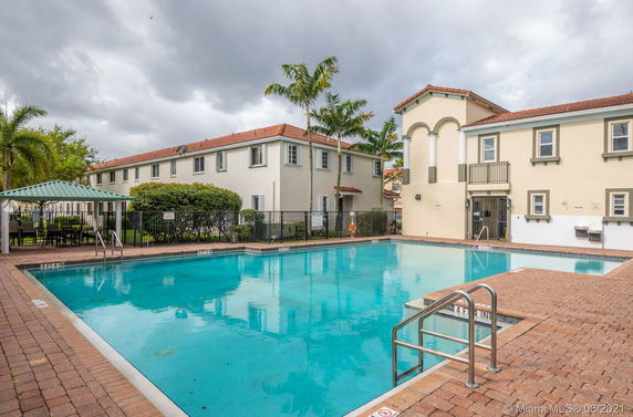 Outdoor swimming pool next to a multi-story residential building.