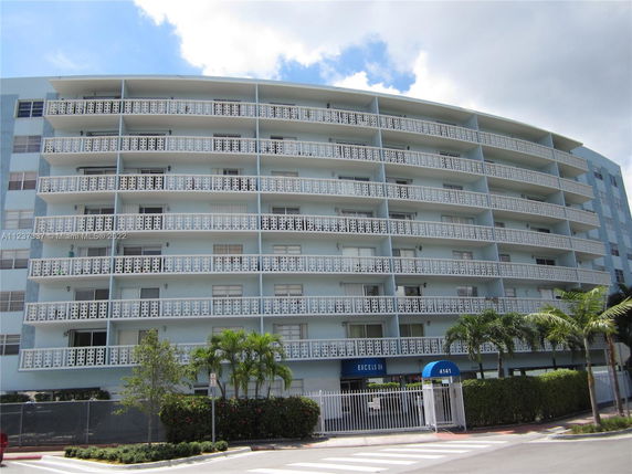 Front view of a multi-story building with decorative balcony railings.