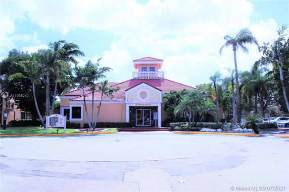 Front view of a building with a tiled roof and a tower-like structure on top.