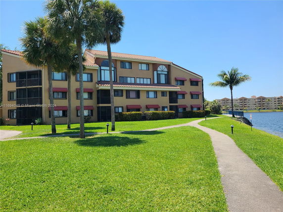 Front view of a multi-story apartment building near a water body.