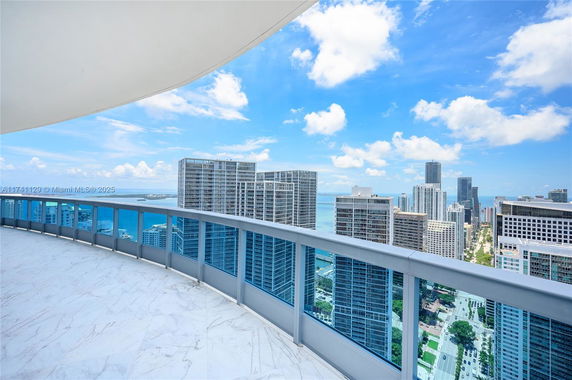 Panoramic view from a high-rise building showing a cityscape with skyscrapers and water on a clear day.