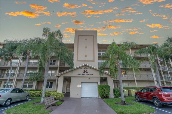 Front view of a multi-story residential building with balconies and a covered entrance.