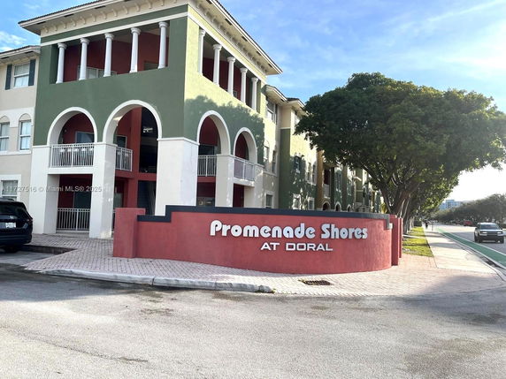 Front view of a multi-story residential building with arches and balustrades.