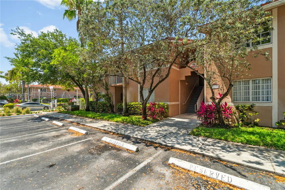 Outdoor parking area in front of a multi-story residential building.