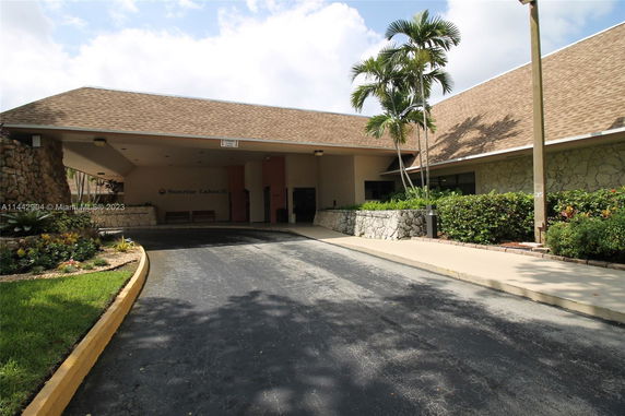 Front view of a building with a covered entryway and stone walls.