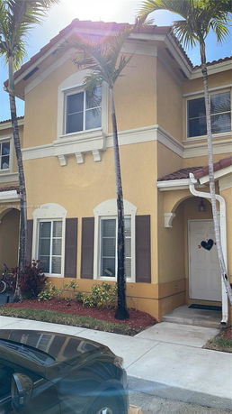 Front view of a two-story house with yellow exterior and white trims.