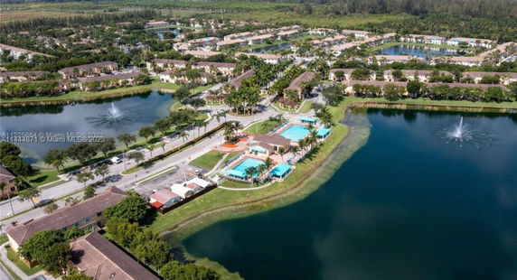 Wide aerial view of a residential area with lakes and community pools.