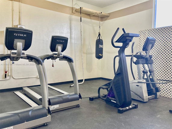 Indoor gym area with fitness equipment, including treadmills and a punching bag.