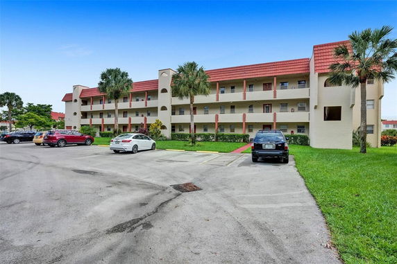Front view of a three-story apartment building with multiple balconies.