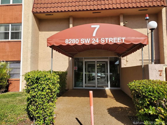 Front view of a building with an entrance canopy labeled with an address.