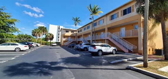 Outdoor parking area in front of a multi-story building.
