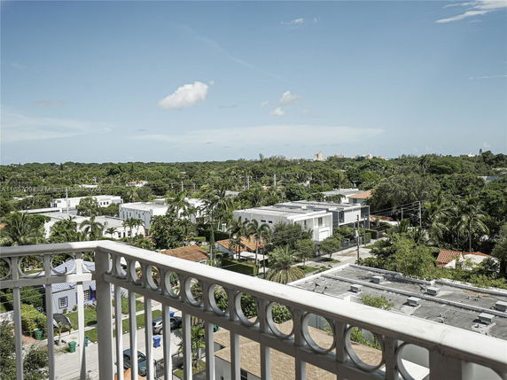 View from a balcony showing surrounding residential buildings and greenery.
