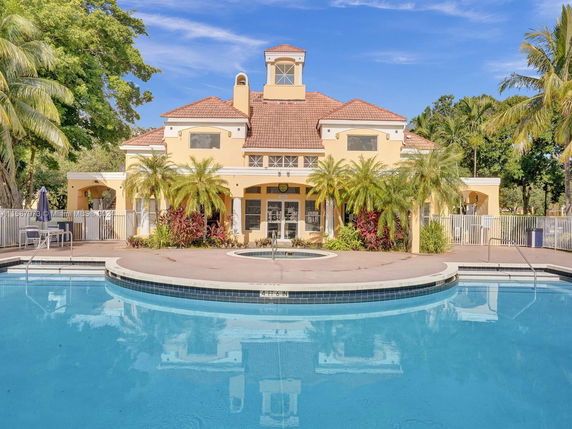 Front view of a building with a swimming pool in the foreground.