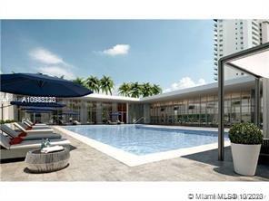 Outdoor pool area surrounded by modern buildings and palm trees.
