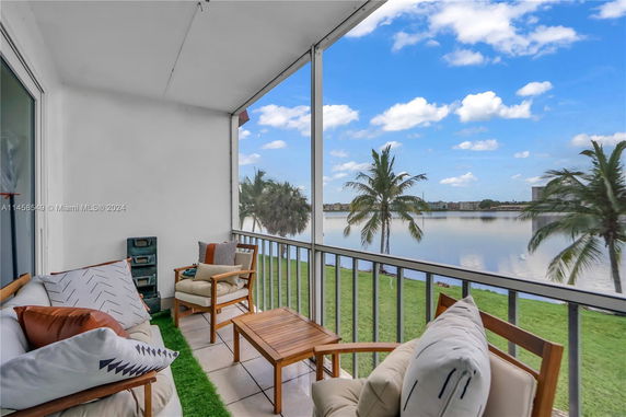 Balcony with a view of a lake and palm trees.