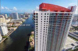 High-rise building with numerous balconies and a distinctive red top.