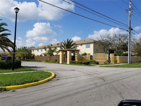 Front view of a multi-story residential building complex with a gated entrance.