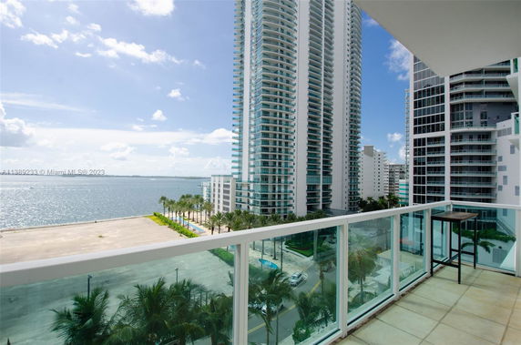 High-rise buildings viewed from a balcony with a sea view.