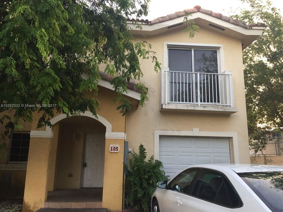 Front view of a two-story house with a small balcony and attached garage.