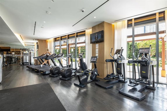 Modern gym with treadmills, elliptical machines, and exercise equipment.