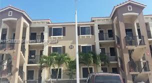 Front view of a three-story apartment building with balconies.